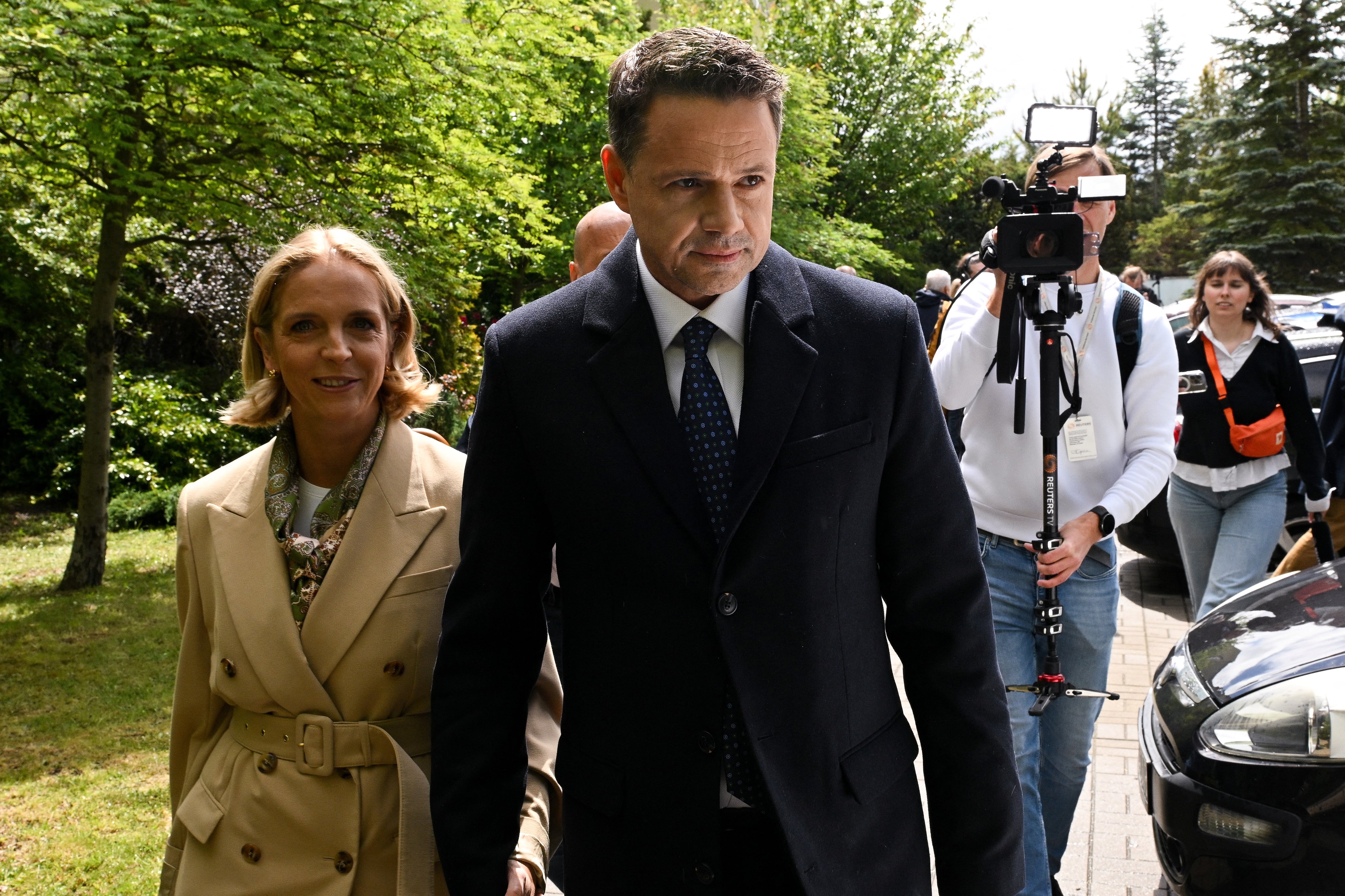El alcalde de Varsovia, Rafal Trzaskowski, candidato presidencial de la Coalición Cívica, y su esposa Malgorzata Trzaskowska caminan fuera del colegio electoral durante la primera vuelta de las elecciones presidenciales de Polonia, en Varsovia, Polonia, el 18 de mayo de 2025. REUTERS/Kasia Strek