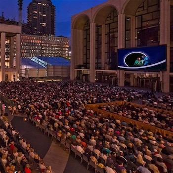 Miles de personas se reúnen frente al Metropolitan Opera para seguir las producciones de Live in HD proyectadas sobre una pantalla gigante instalada en la fachada del histórico edificio.