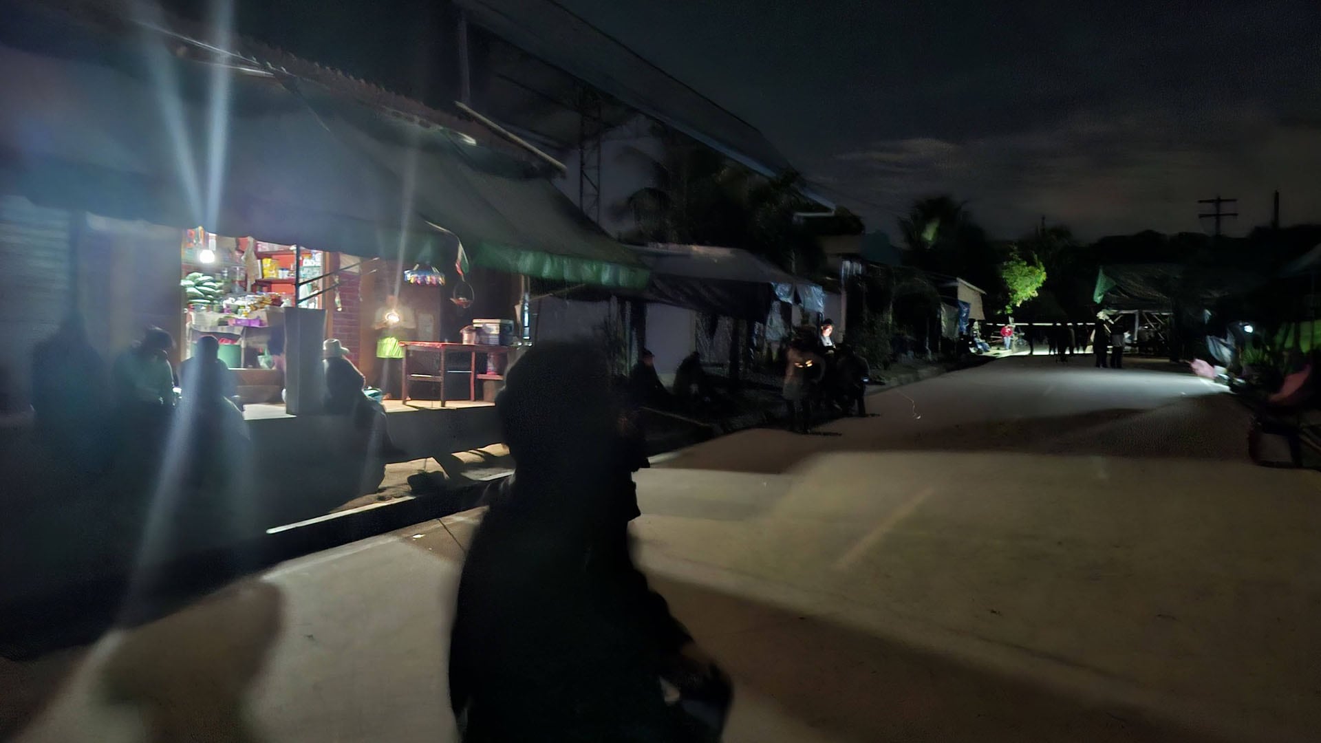 Residentes en una comunidad rural del bastión de Evo Morales se agrupan en las calles y cerca de una tienda con luz limitada, tras un apagón nocturno el 28 de mayo de 2026.