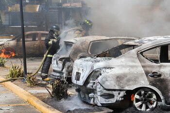 Bomberos rocían con agua varios