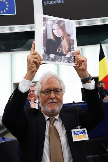 Héctor Abad Faciolince levanta en septiembre del 2023 en el Parlamento europeo una foto de la escritora ucraniana Victoria Amelina, muerta luego de un ataque ruso con misiles en junio de ese año. Abad sobrevivió al ataque. (REUTERS/Yves Herman)