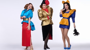 Tres mujeres con vestuario teatral. Izquierda: blusa azul y falda roja. Centro: chaqueta dorada y falda negra. Derecha: vestido azul y delantal amarillo