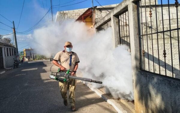 Un operario de saneamiento ambiental aplica un químico con una máquina fumigadora portátil en una calle residencial en Guatemala (Ministerio de Salud Pública y Asistencia Social de Guatemala)