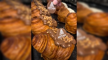 Varias piezas de hojaldre decoradas con crema de chocolate, frutos picados y distintivos comestibles con la marca Artiaga.