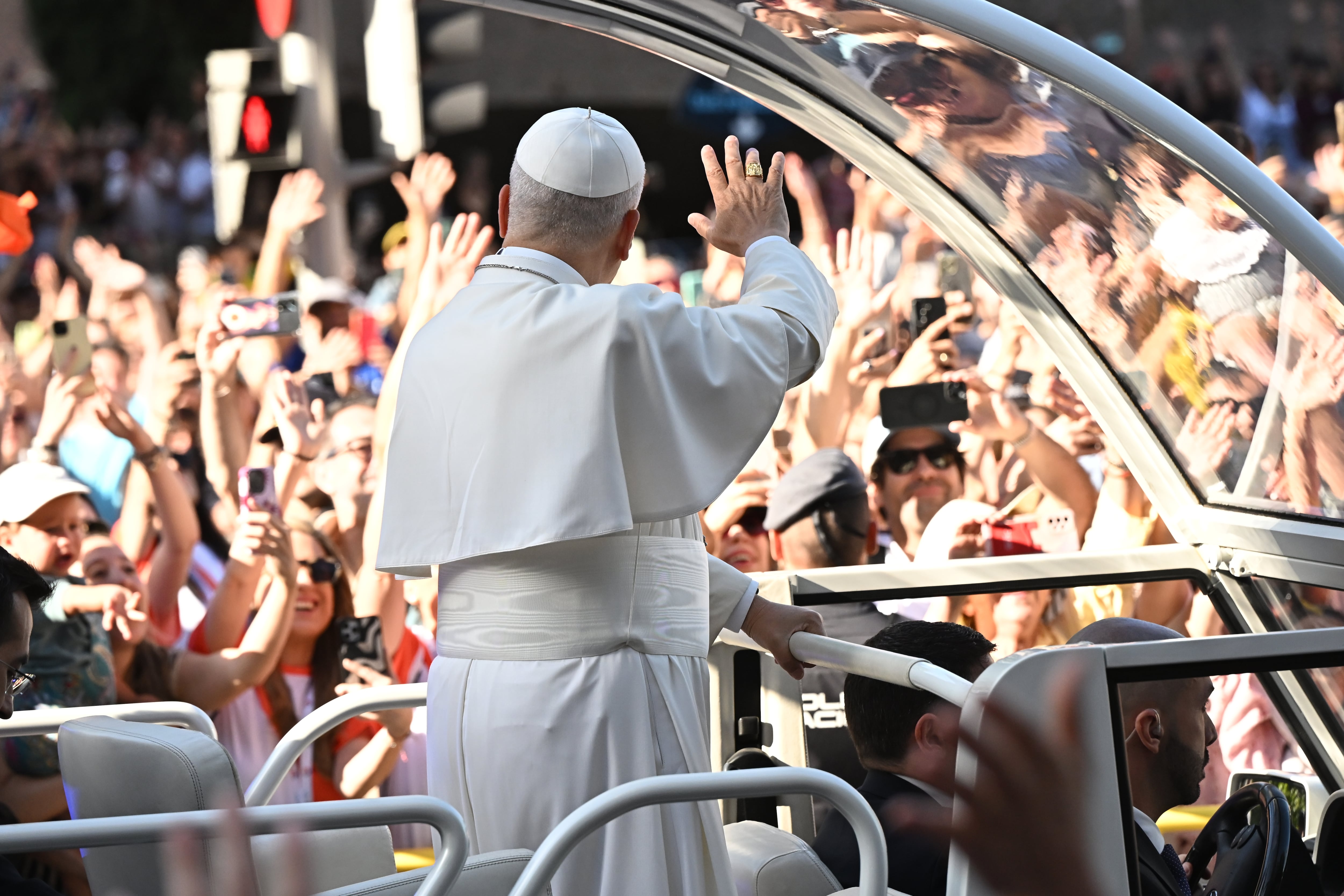 El papa León XIV recorre las calles del centro de la capital en el papa móvil mientras se dirige a la plaza Cibeles para oficiar la misa del Corpus Christi, en Madrid. (EFE/ Fernando Villar).
