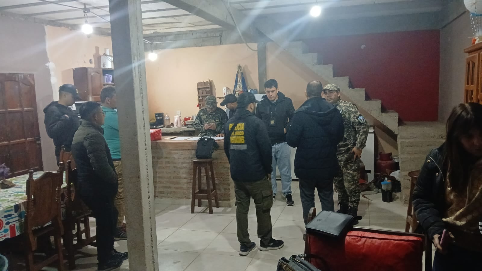 El personal policial y judicial realiza tareas de inspección y registro en el interior de una de las viviendas allanadas