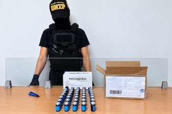 La Policía Nacional interceptó 50 frascos cilíndricos con presunta heroína durante una diligencia de allanamiento en un centro de procesamiento postal de Tocumen. Tomada de la PN