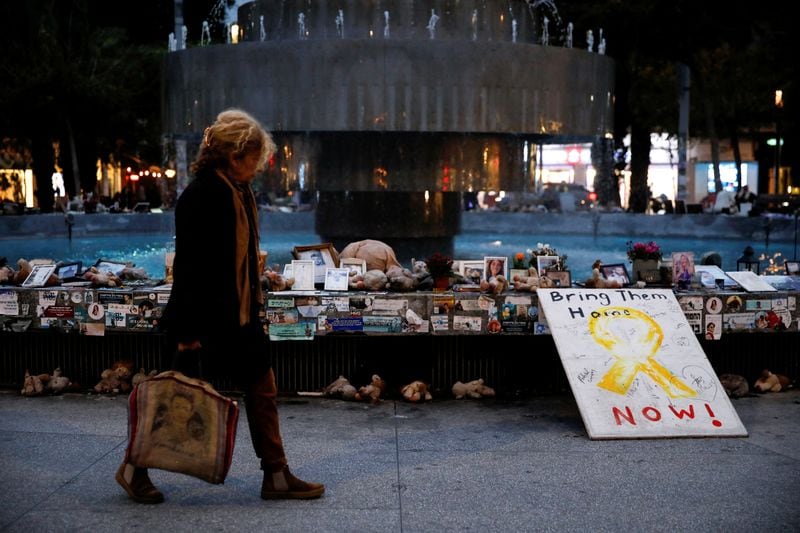 Una mujer camina junto a fotos y recuerdos relacionados con soldados caídos, rehenes y personas asesinadas durante el ataque de Hamás del 7 de octubre de 2023, en la plaza Dizengoff, en Tel Aviv, Israel. 10 de febrero de 2025
REUTERS/Shir Torem