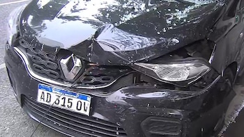 Vista cercana del frente de una camioneta negra con la parte delantera gravemente dañada: capó abollado, faro roto y matrícula argentina visible