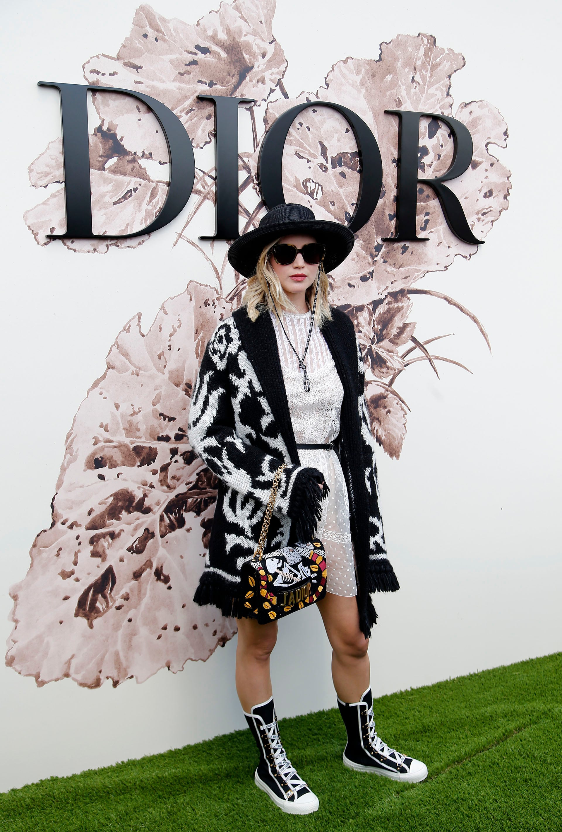 En el desfile Haute Couture de Christian Dior en París (2017), optó por un vestido blanco de encaje con cárdigan tejido, sombrero y botas de caña alta (AP/Thibault Camus)