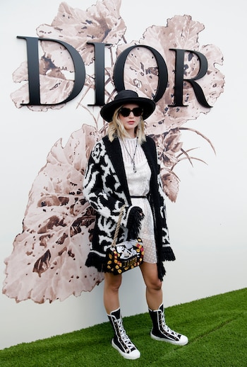 En el desfile Haute Couture de Christian Dior en París (2017), optó por un vestido blanco de encaje con cárdigan tejido, sombrero y botas de caña alta (AP/Thibault Camus)