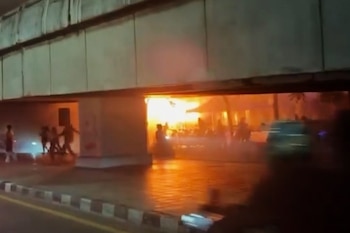Personas se desplazan entre las llamas durante el incendio en el bar de Bangkok, en una imagen tomada de un video (archivo vía Instagram @jackfanchan/AP)