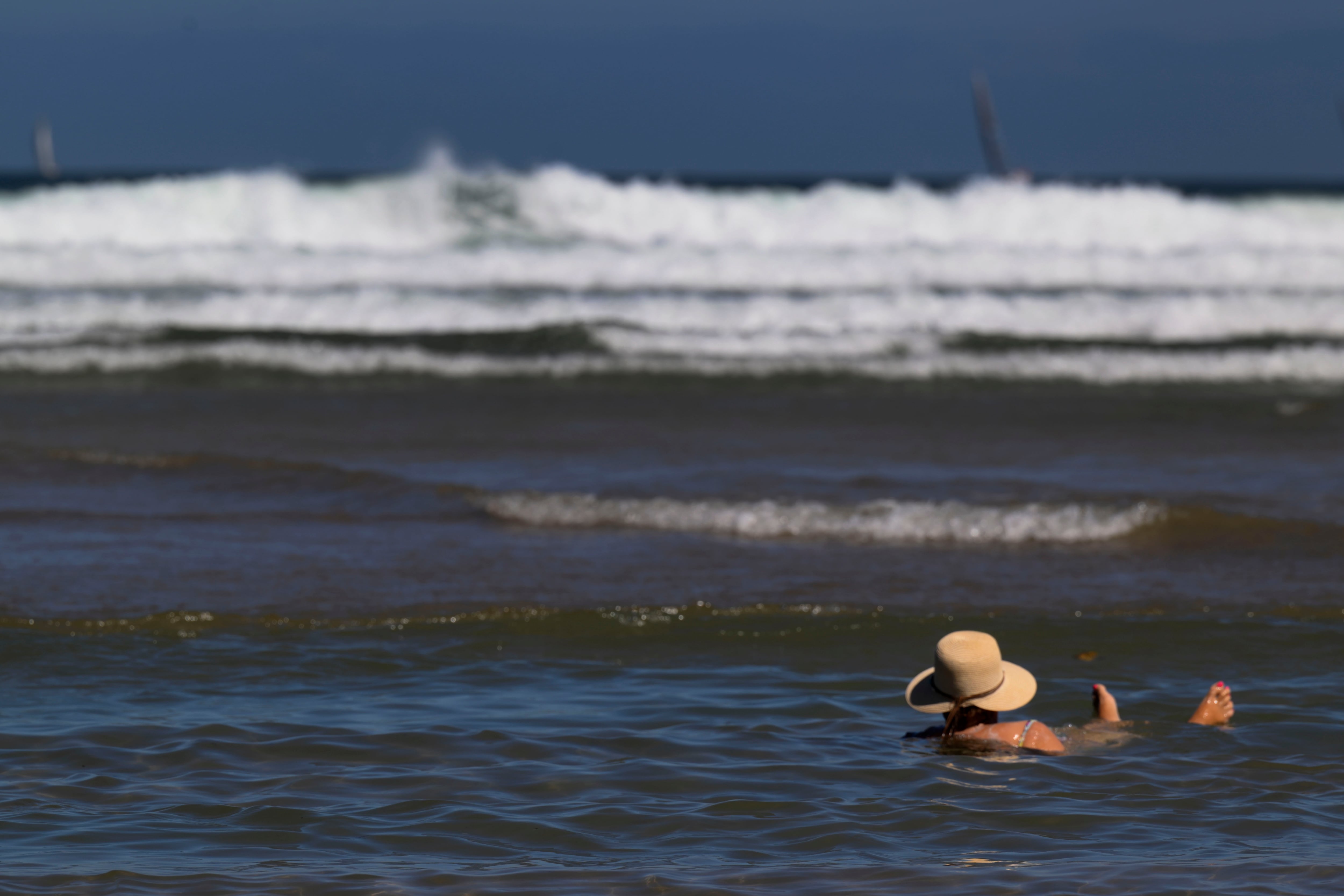 Una mujer en la playa de San Lorenzo, a 13 de septiembre de 2026. (EFE/ Eloy Alonso)