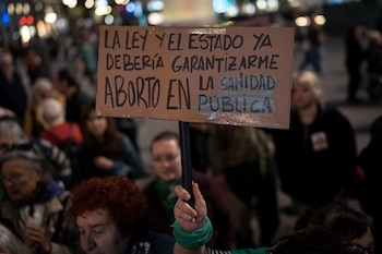 Una persona sostiene una pancarta durante una concentración en Madrid bajo el lema 'No nos vamos. Ayuso, nos quedamos'. (Diego Radamés / Europa Press)