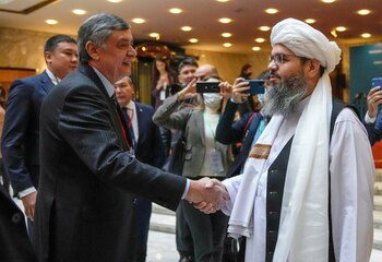 Russian presidential envoy to Afghanistan Zamir Kabulov shakes hands with a representative of the Taliban delegation Mawlawi Shahabuddin Dilawar before the beginning of international talks on Afghanistan in Moscow, Russia, October 20, 2021. Alexander Zemlianichenko/Pool via REUTERS