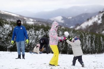 Varias personas juegan con nieve,