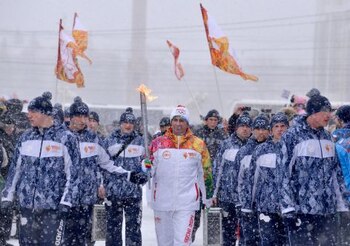 A torchbearer carries an Olympic