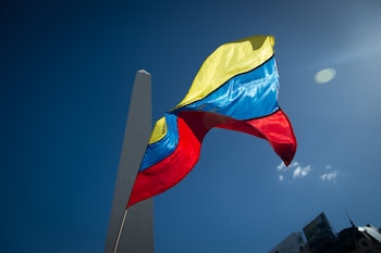 Una bandera venezolana flamea frente