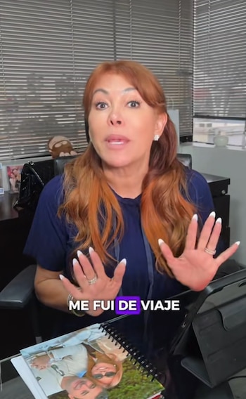 Magaly Medina, cabello rojizo, camisa azul oscuro, gesticula con las manos; texto 'ME FUI DE VIAJE'; calendario con fotos y persianas de oficina