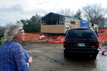 Una vecina observa los daños del incendio en el que murieron nueve personas (AP)