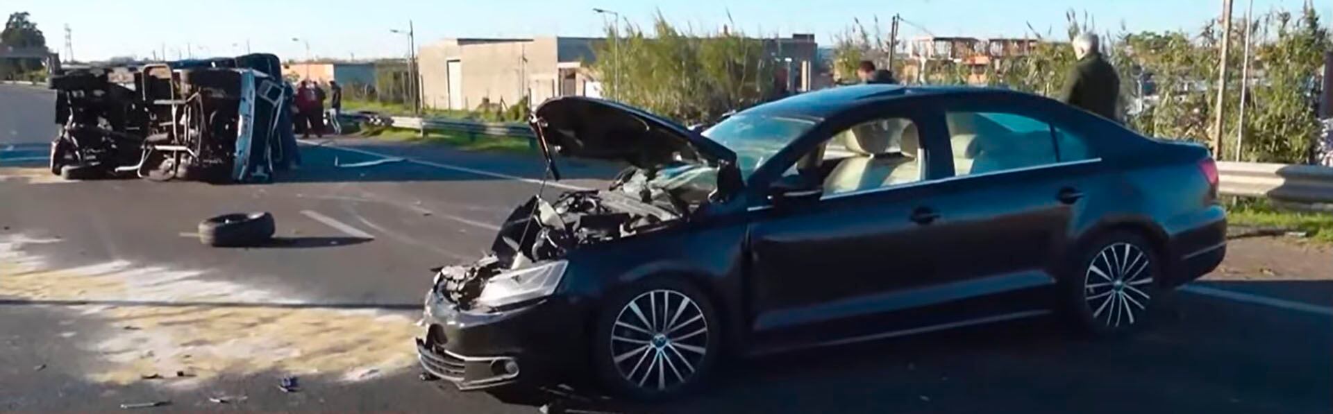 De fondo, la camioneta Ford F-100 volcada. Adelante, el Volkswagen modelo Vento destrozado en su parte delantera.