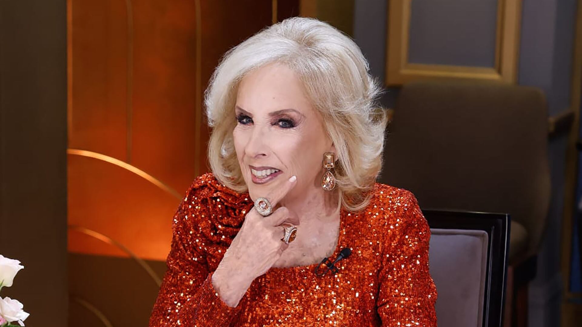 Mirtha Legrand, conductora de televisión, sonríe luciendo un deslumbrante vestido rojo de lentejuelas durante una emisión de