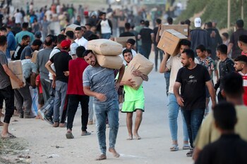 Palestinos transportan paquetes de ayuda