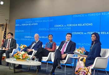 Cinco panelistas sentados en un evento del Council on Foreign Relations. Fondo azul con texto del consejo, mesas con flores, vasos de agua y bandera de EE. UU. a la izquierda