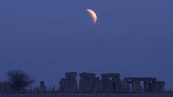 Luna llena durante un eclipse, antes del amanecer, en el círculo de piedras de Stonehenge, cerca de Amesbury, en el sur de Gran Bretaña, el 14 de marzo de 2025. (REUTERS/Toby Melville).