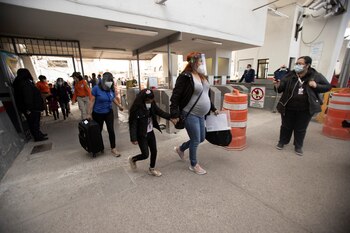 Fotografía de varios inmigrantes repatriados en el Cruce Internacional Santa Fe en El Paso, Texas. EFE/Jesús Rosales.