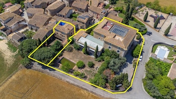 Vista aérea del Castell d’Orriols con el perímetro de la finca marcado en amarillo, rodeado de casas, campos, jardines y una piscina.