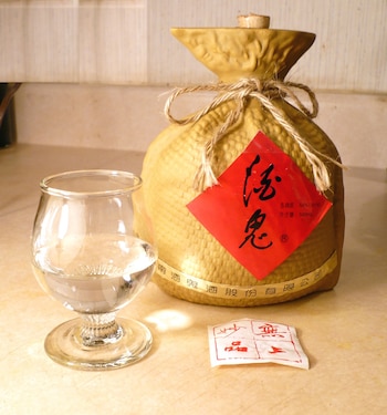 Botella de Baijiu, un licor destilado generalmente del sorgo, aunque se pueden utilizare otros granos, de origen chino, junto a una copa