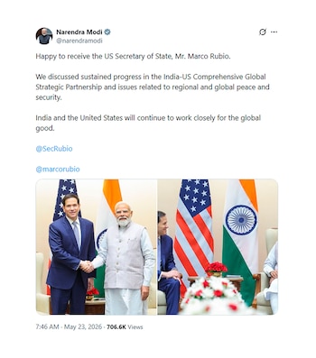 Narendra Modi y Marco Rubio se estrechan la mano en una sala con las banderas de India y Estados Unidos. Modi lleva un chaleco beige, Rubio un traje azul