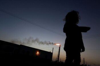 FOTO DE ARCHIVO: Una niña se para frente a su casa mientras la refinería Cardón, que pertenece a la petrolera estatal venezolana PDVSA, es vista al fondo, en Punto Fijo, Venezuela, foto tomada el 22 de 2016. REUTERS/Carlos Jasso