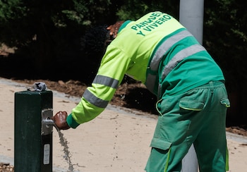 Un trabajador coge agua en