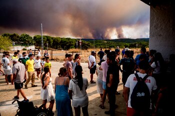 Vecinos de El Madroño, en Sevilla, observan este el fuego del incendio de Niebla, a 9 de agosto de 2026. (EFE/Mauri Buhigas)