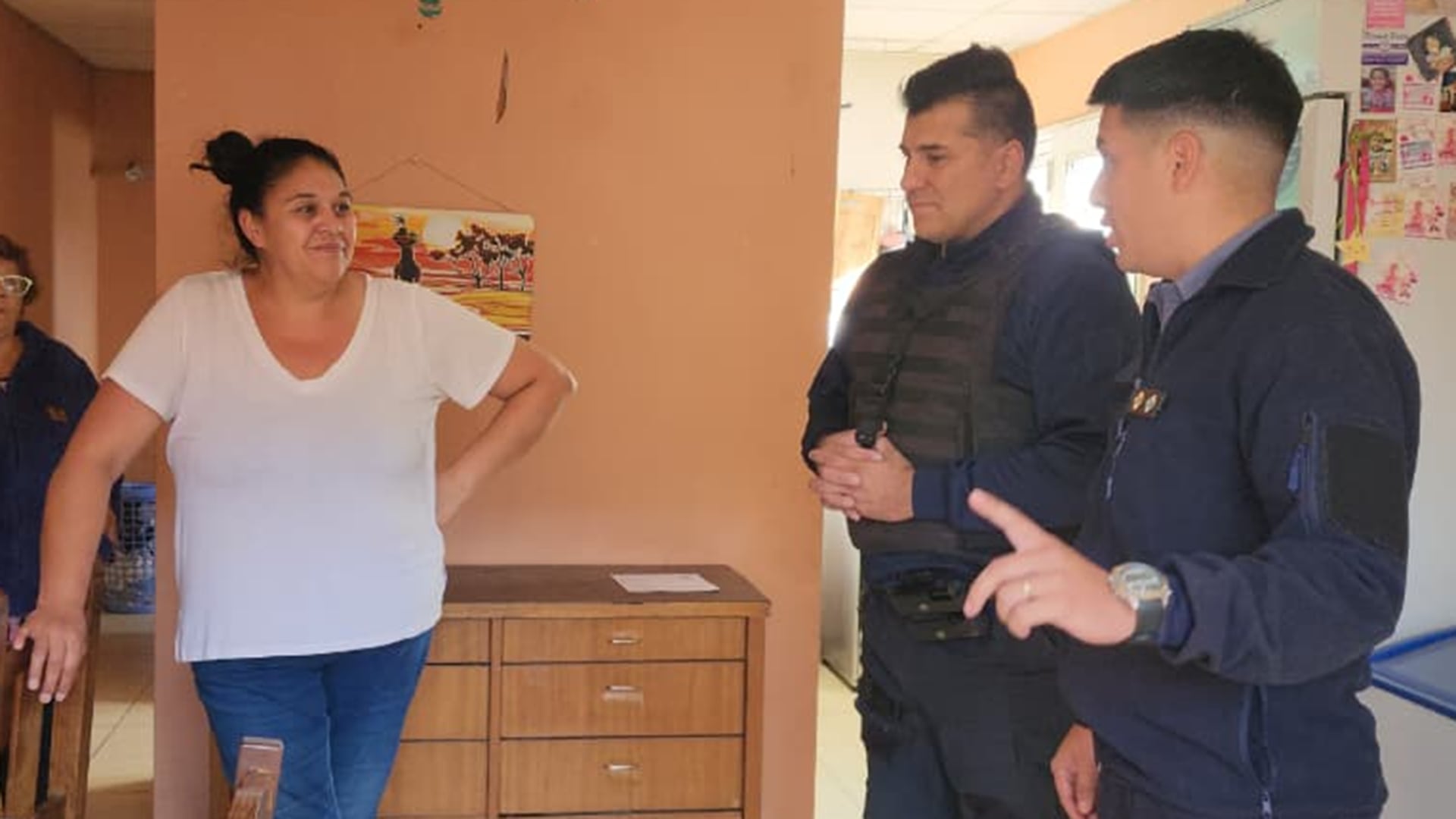 Oficiales de policía dialogan con la madre de un menor que fue asistido por ellos tras sufrir una obstrucción en las vías respiratorias, en una rápida y efectiva intervención en el hogar. (Policía de Río Negro)