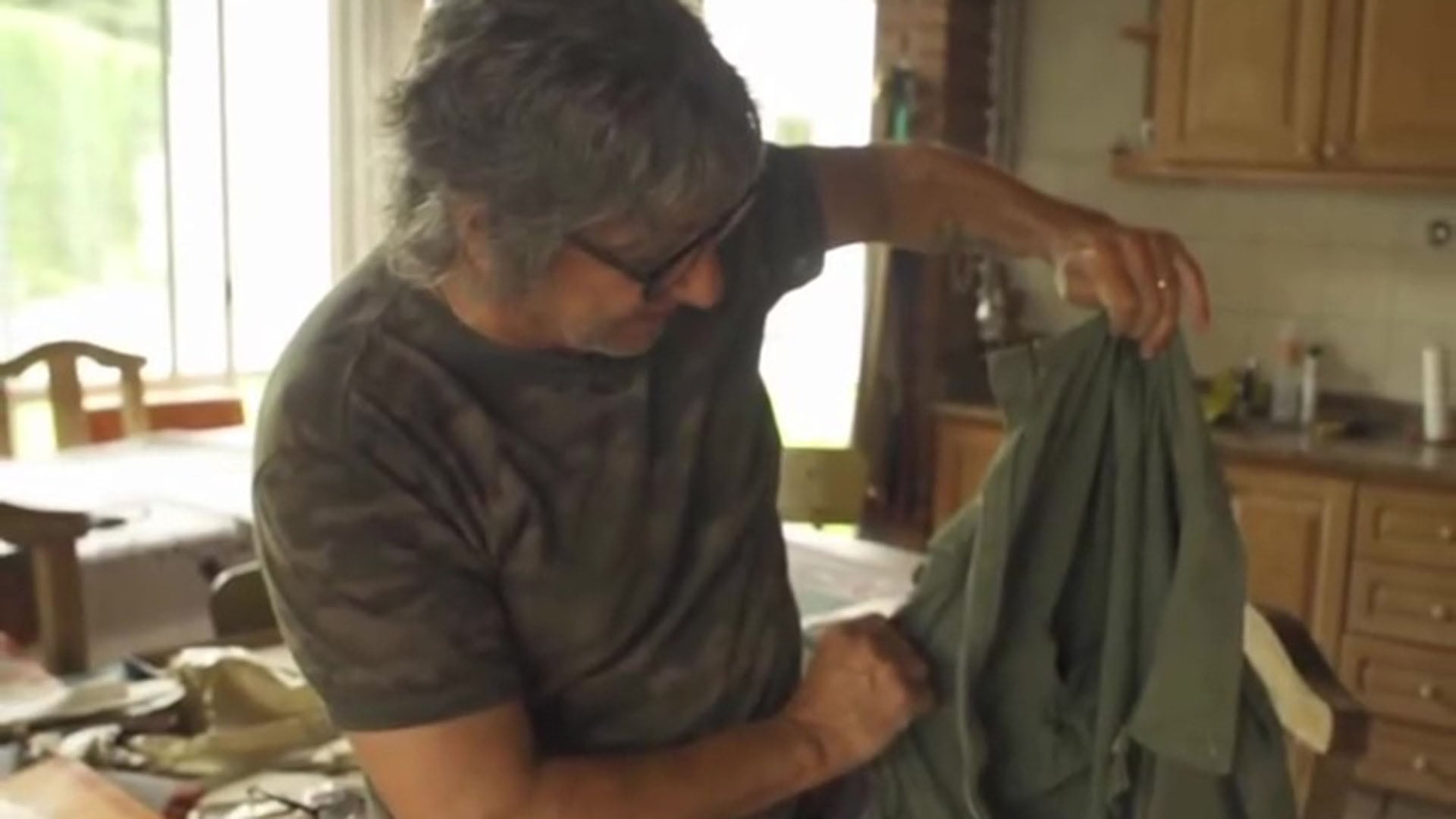 Maffia soseniendo la chaqueta verde que usó durante su participación en la guerra (Captura de video)