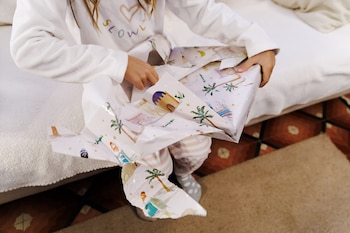 Una niña abre sus regalos