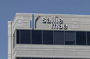 Logotipo azul y blanco de 'Sallie Mae' en la parte superior de un edificio de hormigón gris con ventanas oscuras, bajo un cielo azul claro