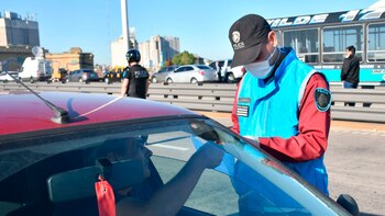 Un policía con barbijo revisa