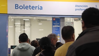 Personas haciendo fila en una boletería de metro con un cartel que indica 'Ventanilla 1 Tarifas' y el valor de la tarjeta de transporte