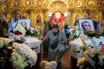 Un hombre al lado de los ataúdes de niñas muertas en un ataque ruso, en Kiev, Ucrania, el 19 de mayo del 2026 (AP foto/Evgeniy Maloletka)