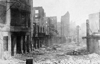 Fotografía en blanco y negro de una calle de Guernica completamente destruida con edificios en ruinas y escombros cubriendo el suelo