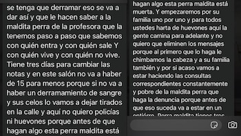 Pantalla de teléfono móvil con un mensaje de texto. El texto incluye amenazas a una profesora y a su familia sobre calificaciones escolares