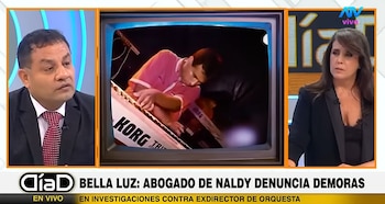 Pantalla de programa de televisión dividido en tres con un hombre de traje, un televisor que muestra un músico con teclado Korg, y una mujer de blazer oscuro