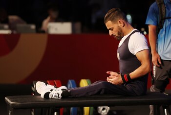 Hadj Ahmed Beyour, de Algeria, se prepara para su levantamiento en la final de halterofilia de menos de 49 kilos