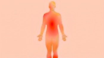 Silueta humana difuminada en tonos naranja, rojo y amarillo sobre un fondo melocotón claro. El color rojo es más intenso en el centro del torso y en los pies.