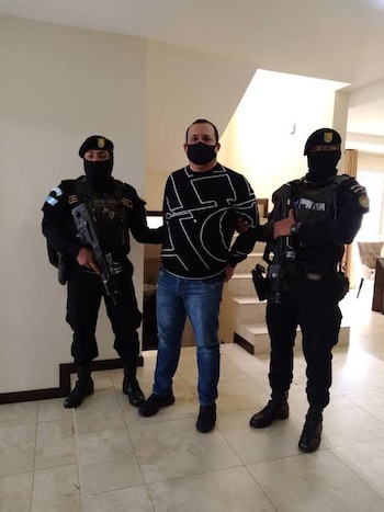 Un hombre con el rostro difuminado sube la escalerilla de un avión pequeño junto a otra persona en una pista de aterrizaje