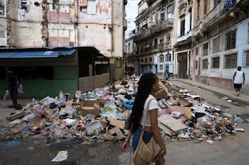 La gente pasa junto a un montón de basura en una calle del barrio de Centro Habana, en La Habana, el 13 de junio de 2026 (Pablo Porciuncula/AFP)